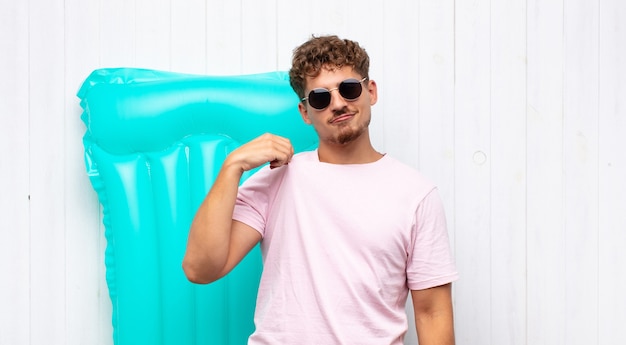 Hombre joven que parece arrogante, exitoso, positivo y orgulloso, apuntando a sí mismo. concepto de vacaciones