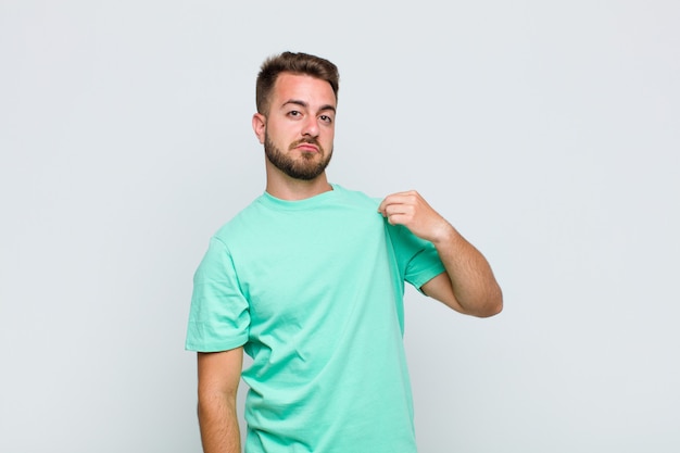 Foto hombre joven que parece arrogante, exitoso, positivo y orgulloso, apuntando a sí mismo