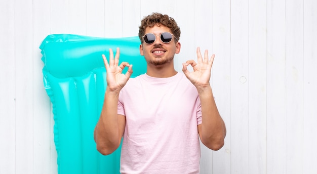 Foto hombre joven que parece concentrado y meditando, sintiéndose satisfecho y relajado, pensando o haciendo una elección