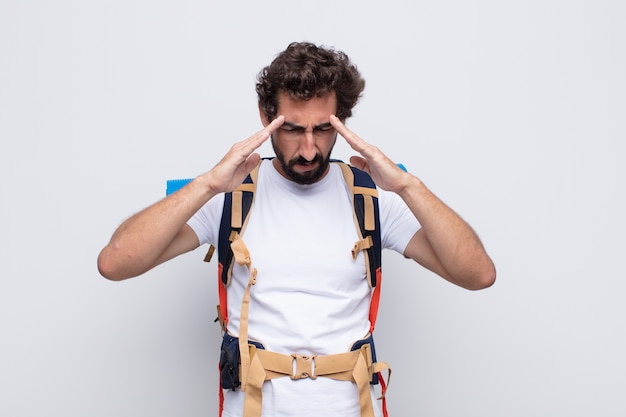 Hombre joven que parece concentrado, pensativo e inspirado, intercambiando ideas e imaginando con las manos en la frente