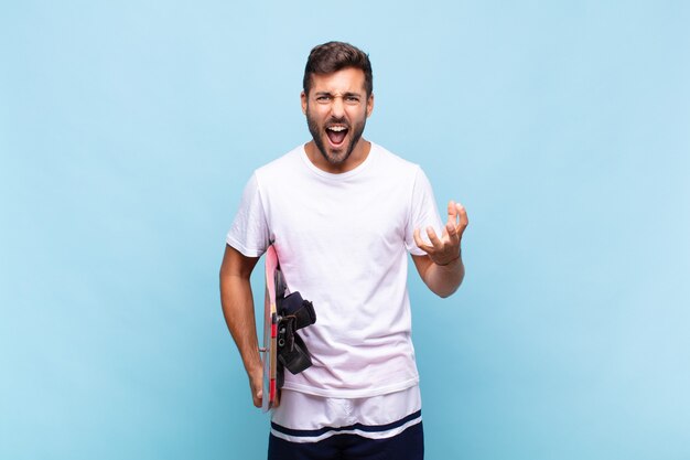 Hombre joven que parece enojado, molesto y frustrado gritando wtf o qué te pasa