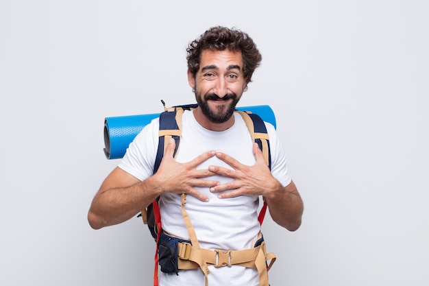 Hombre joven que parece feliz, sorprendido, orgulloso y emocionado, apuntando a sí mismo