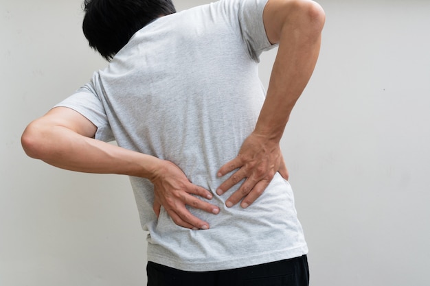 Hombre joven que retiene el dolor. Concepto medico