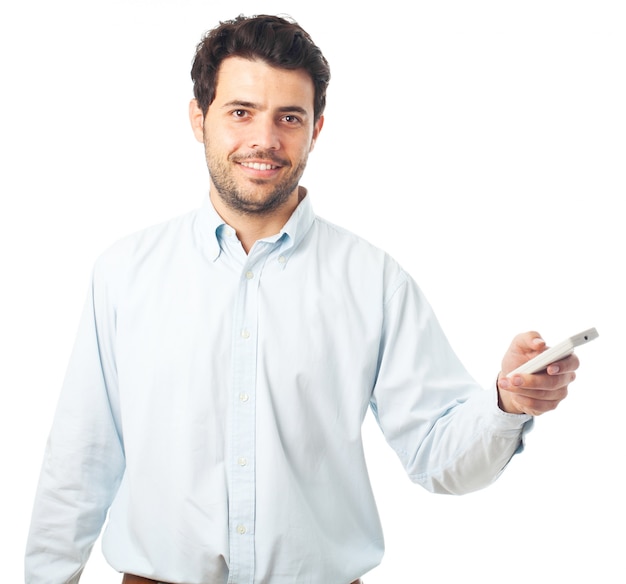 Foto hombre joven que señala con un control remoto sobre un fondo blanco