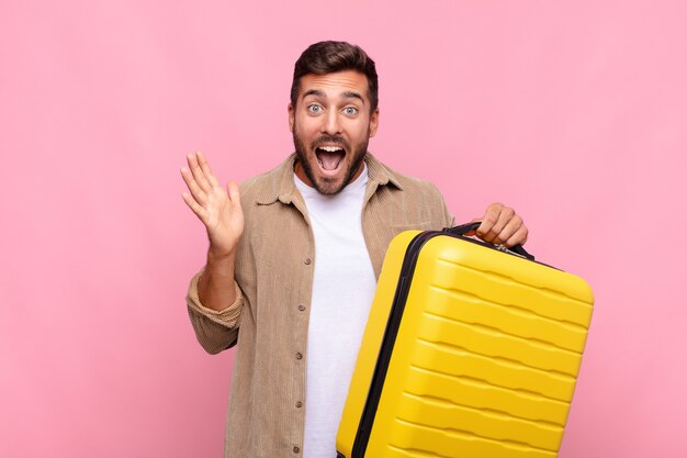 Hombre joven que se siente feliz, emocionado, sorprendido o conmocionado, sonriendo y asombrado por algo increíble. concepto de vacaciones