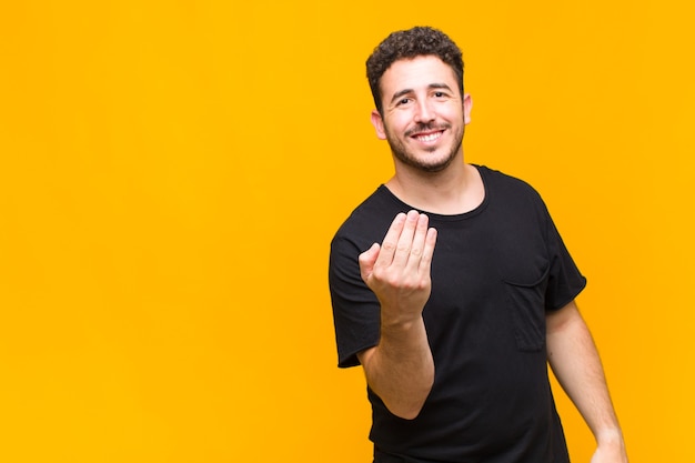 Hombre joven que se siente feliz, exitoso y confiado, enfrenta un desafío y dice ¡adelante! o dándote la bienvenida