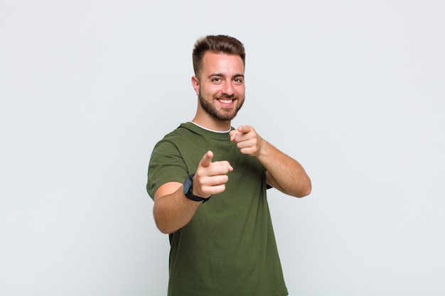 Foto hombre joven que se siente feliz, fresco, satisfecho, relajado y exitoso