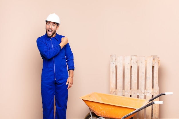 Hombre joven que se siente feliz, positivo y exitoso, motivado cuando se enfrenta a un desafío o celebra el concepto de construcción de buenos resultados