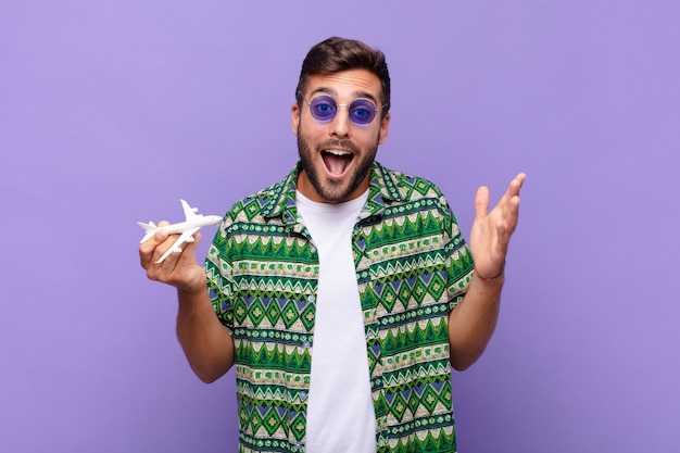 Hombre joven que se siente feliz, sorprendido y alegre, sonriendo con actitud positiva aislada