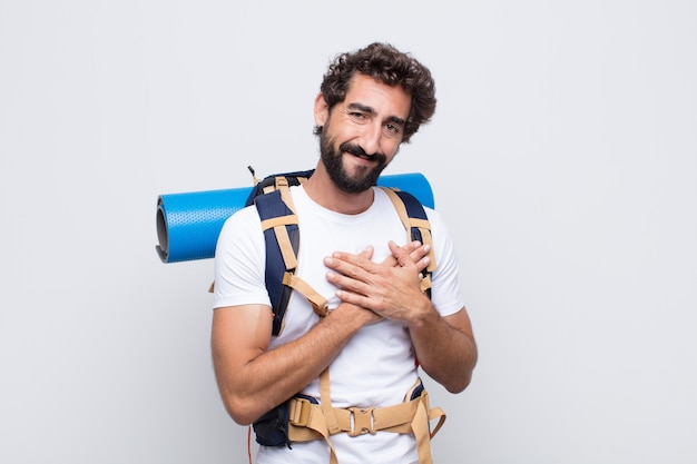 Hombre joven que se siente romántico, feliz y enamorado, sonriendo alegremente y tomados de la mano cerca del corazón