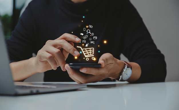 Foto hombre joven que usa el teléfono inteligente con el icono del carrito de compras