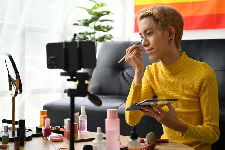Foto hombre joven queer belleza maquillador o vlogger grabación tutorial de maquillaje en el hogar