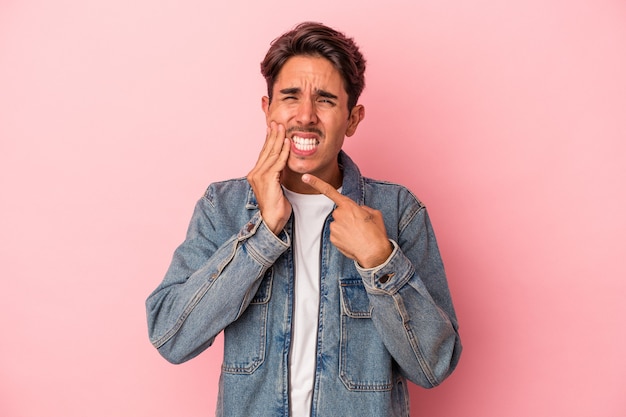 Hombre joven de raza mixta aislado sobre fondo blanco con un fuerte dolor de dientes, dolor de muelas.