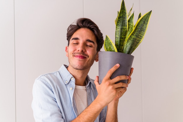 Hombre joven de raza mixta con una planta en una cocina