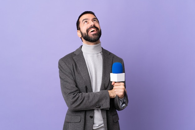 Hombre joven reportero sobre pared aislada