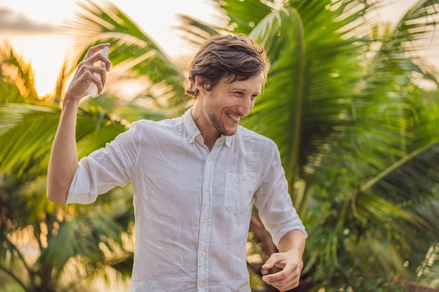 Foto hombre joven rociar repelente de insectos mosquitos en la protección contra insectos forrest