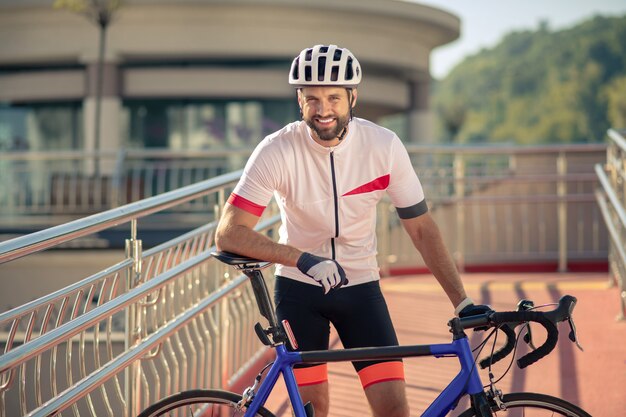 Hombre joven en ropa deportiva con una bicicleta