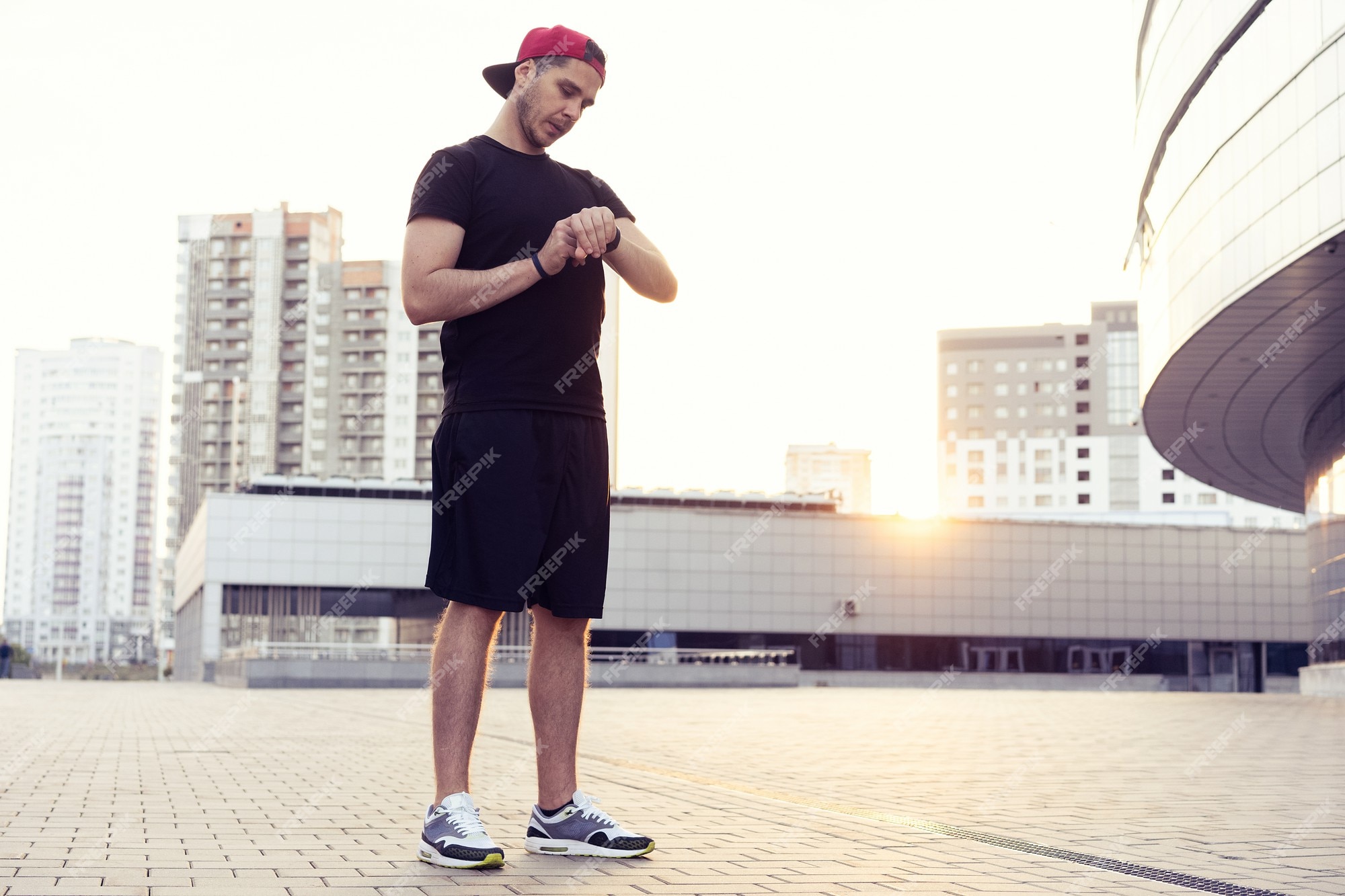 joven en ropa deportiva. hombre urbano se prepara para hacer jogging en la ciudad. hacer ejercicio urbano | Foto Premium