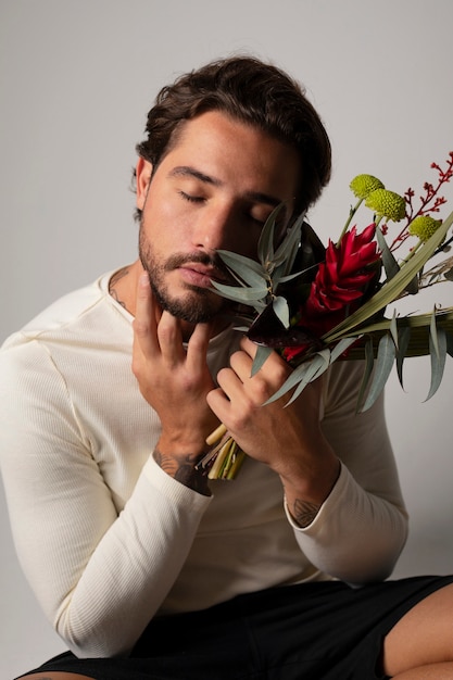 Foto hombre joven y sensible con flores.