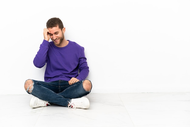 Foto hombre joven sentado en el suelo riendo