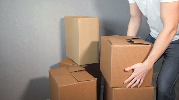 El hombre joven del servicio de entrega tiene una gran cantidad de caja de cartón.