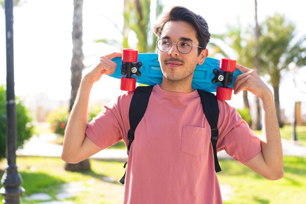 Hombre joven con skate al aire libre