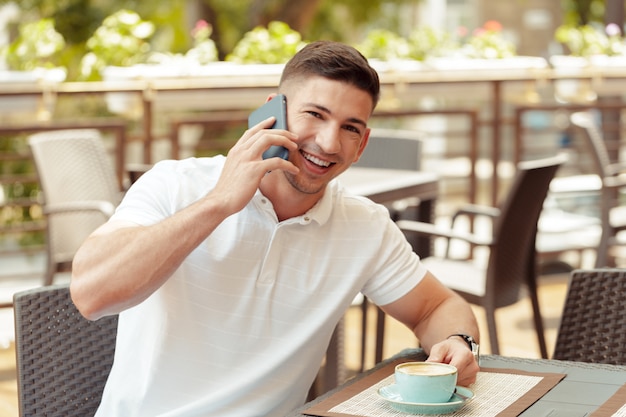 Hombre joven con smartphone en café