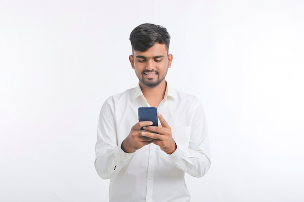 Hombre joven con smartphone sobre fondo blanco.