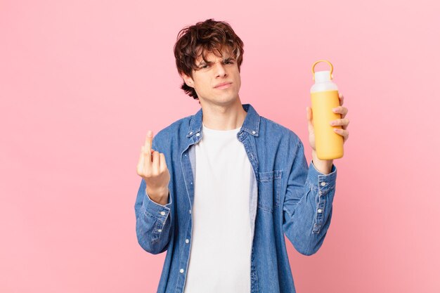 Hombre joven con un smoothy sintiéndose enojado, molesto, rebelde y agresivo.