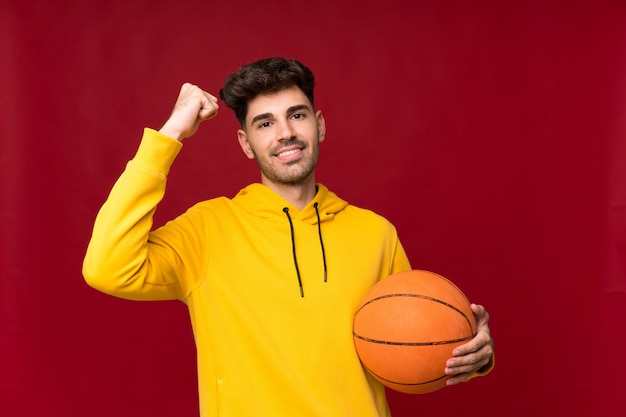 Hombre joven sobre aislado con pelota de baloncesto