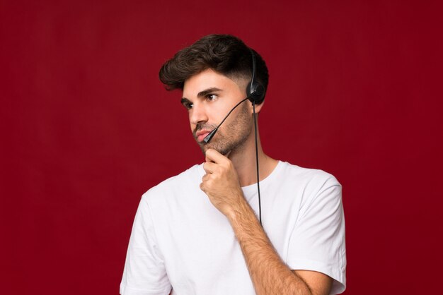 Hombre joven sobre aislado trabajando con auriculares