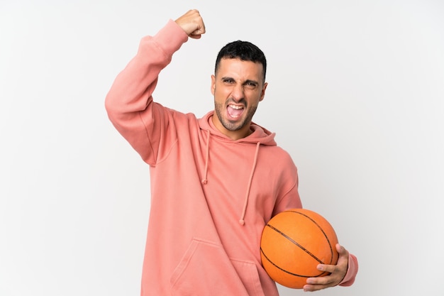 Hombre joven sobre blanco aislado con pelota de baloncesto