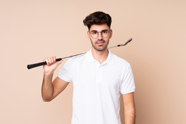 Hombre joven sobre fondo aislado jugando al golf