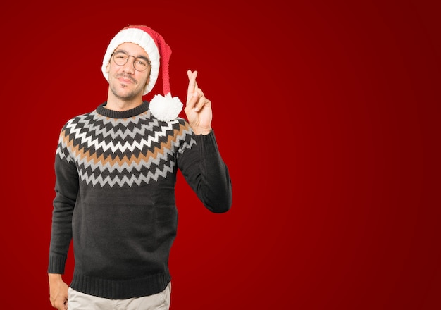 Hombre joven con sombrero de Navidad gesticulando