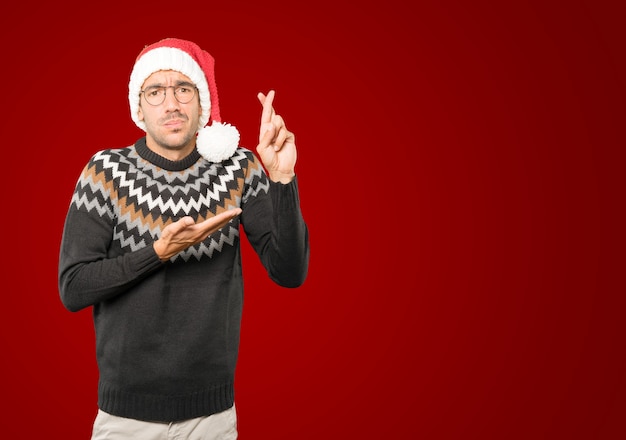 Hombre joven con sombrero de Navidad gesticulando