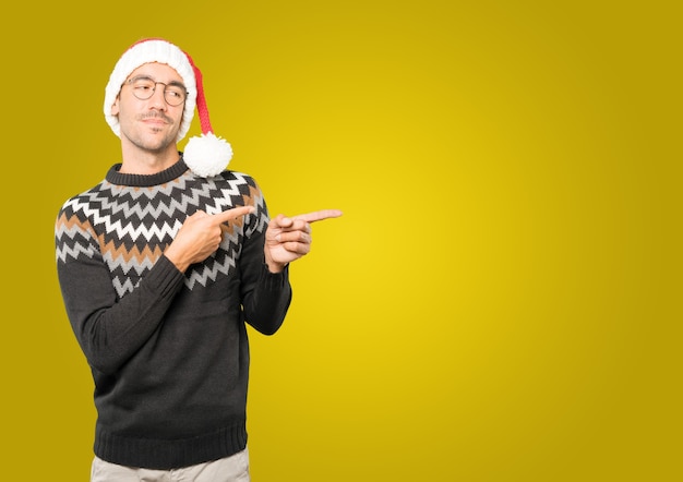 Hombre joven con sombrero de Navidad gesticulando