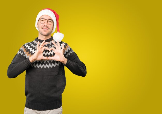 Hombre joven con sombrero de Navidad gesticulando