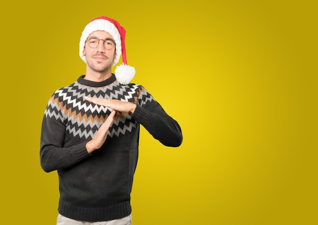 Hombre joven con sombrero de Navidad gesticulando