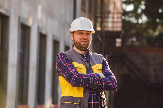 Foto hombre joven con sombrero de pie contra la estructura construida