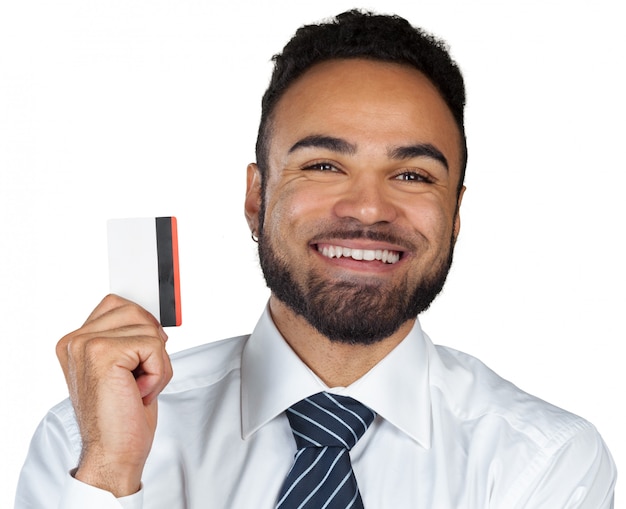 Hombre joven sonriente feliz que sostiene una tarjeta de crédito aislada en blanco