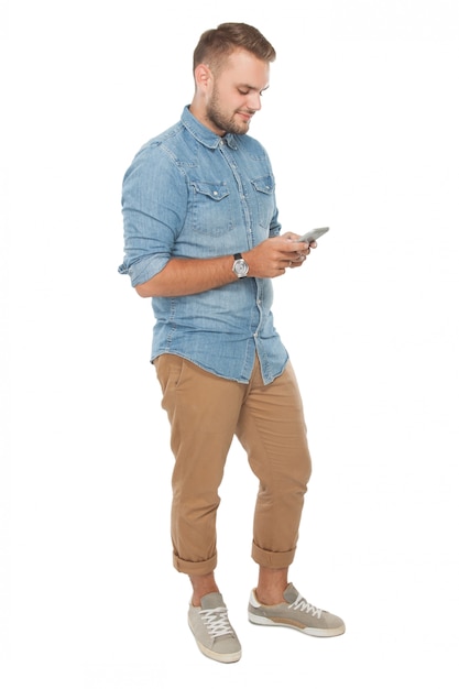Hombre joven y sonriente mirando su teléfono celular