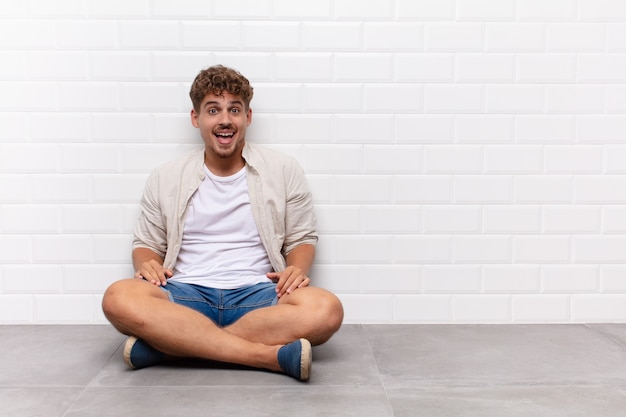 Hombre joven con una sonrisa grande, amigable y despreocupada, de aspecto positivo, relajado y feliz, escalofriante