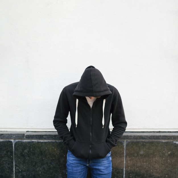 Foto hombre joven en sudadera con capucha negra