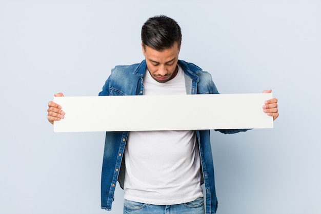 Hombre joven del sur de Asia con un cartel blanco.