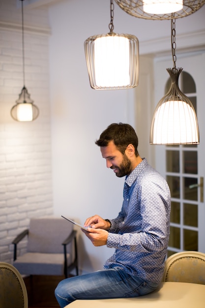 Hombre joven con tableta digital en la habitación