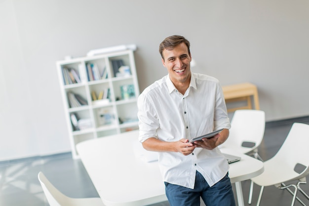 Foto hombre joven con tableta en la oficina