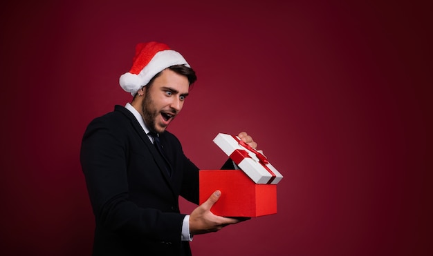 Hombre joven en traje y gorro de Papá Noel