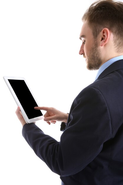 Hombre joven en traje con tableta, en blanco