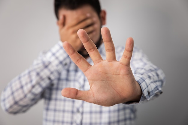 hombre joven triste señal de parada de la mano