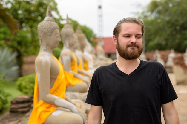 Hombre joven turista barbudo tener vacaciones en Ayutthaya, Tailandia